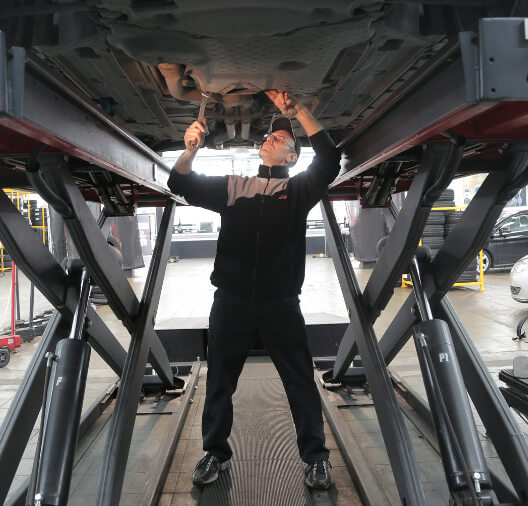 Mecánico bajo un coche